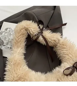 Detail of soft plush beige faux fur shoulder bag with decorative brown bow straps