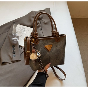 Detail of grey canvas tote with leather knots and plush ice cream charm decoration