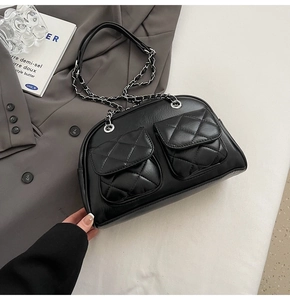 Close-up of black quilted shoulder bag with chain strap and glossy retro leather finish