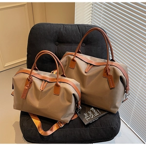 Detailed comparison of khaki nylon travel tote bags in two sizes on a velvet chair