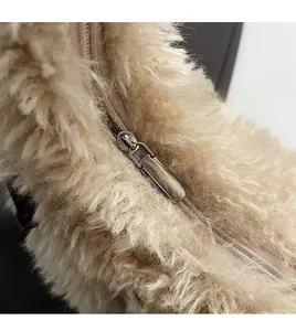Macro detail of the smooth silver metal zipper on a fluffy faux fur shoulder bag