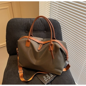 Detail of large nylon travel tote with leather handles and adjustable shoulder strap