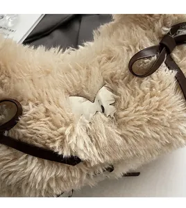 Close-up of beige plush faux fur bag featuring a silver butterfly metal buckle and bow