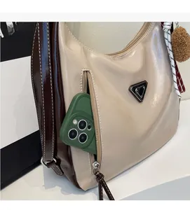 Detailansicht der Hobo-Tasche mit Reißverschlussfach und grünem Smartphone