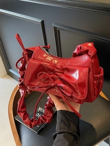 Chic red patent leather handbag with oversized bow detail and pleated scrunchie strap