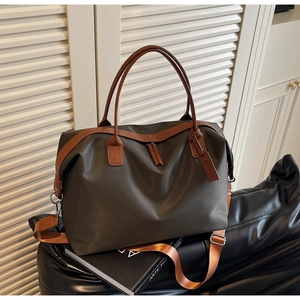 Close-up of durable nylon travel tote with leather handles and adjustable shoulder strap