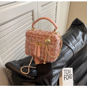 Detail of pink tweed crossbody box bag with gold chain strap and textured fabric