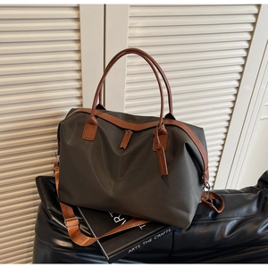 Detail of waterproof nylon travel tote bag with brown leather handles and shoulder strap