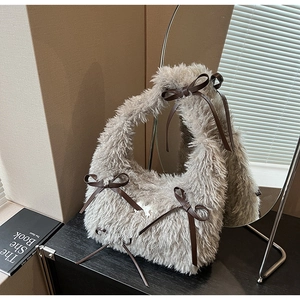 Detailed macro view of soft grey plush faux fur texture and brown bow on the shoulder bag