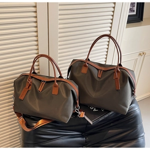 Comparison of large and medium olive grey waterproof nylon tote bags on a leather bench