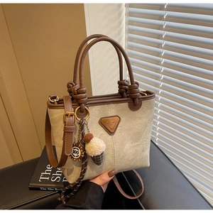 Detail view of canvas bucket bag with leather handles and cute ice cream charm
