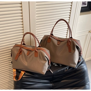 Two-piece grey-brown nylon tote bag set with leather handles on a black textured ottoman