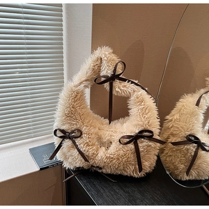 Detailed close-up of fuzzy cream faux fur shoulder bag with decorative brown bows