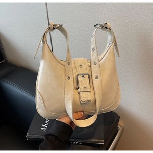 Detail der cremefarbenen Retro-Schultertasche mit silberner Schnalle und Lederstruktur