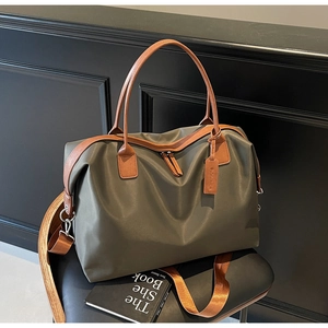 Close-up of olive green nylon tote bag with brown leather handles on a black chair
