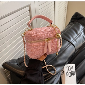 Detailed view of pink tweed mini bag with leather handle and golden chain strap