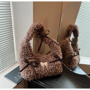Detailed close-up of brown plush hobo bag featuring dark leather bows and soft faux fur texture