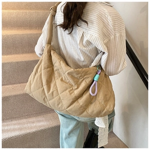 Detailed back view of a large khaki quilted tote bag with a colorful decorative cord