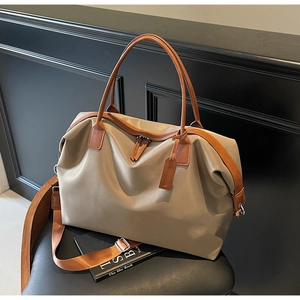 Detail of high-capacity khaki nylon travel tote with premium leather handles and straps