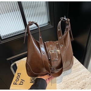 Detail der braunen Vintage-Schultertasche mit poliertem Finish und großer Silberschnalle