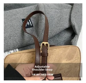 Detail of adjustable leather shoulder strap with gold buckle on a canvas handbag