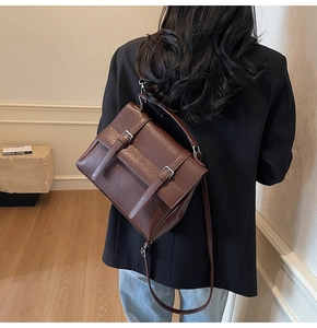Dettaglio della borsa a cartella marrone vintage con doppie cinghie e manico superiore