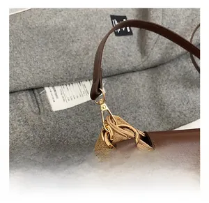 Detail of premium golden metal hook and leather-canvas stitching on women shoulder bag