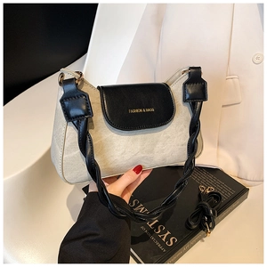 Detail view of contrast underarm bag with twisted handle and adjustable strap