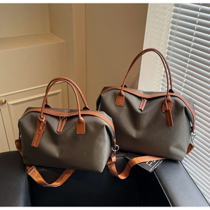 Detail view of nylon travel bags with leather handles and adjustable shoulder straps