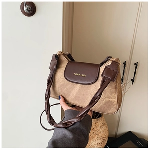 Close-up of khaki and brown拼接 shoulder bag with woven strap and gold lettering