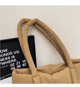 Détail du sac fourre-tout matelassé kaki montrant les poignées en nylon et le rembourrage