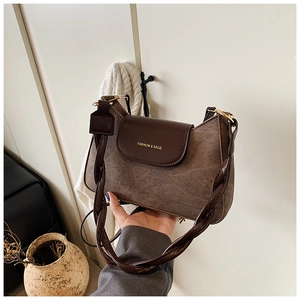 Close-up of retro brown shoulder bag with woven leather strap and gold metal hardware