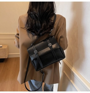 Dettaglio di una borsa a tracolla vintage nera con doppie fibbie e tracolla regolabile