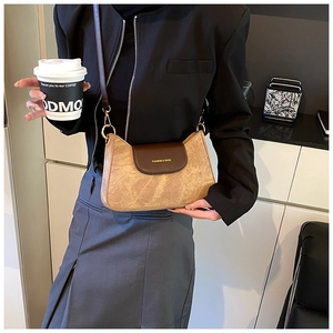 Retro camel and brown crossbody bag with gold hardware shown on a model in a suit