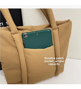 Détail de la poche avant durable sur le sac cabas matelassé kaki montrant une grande capacité