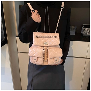 Detail of pink quilted leather backpack with silver chain straps and flap pockets