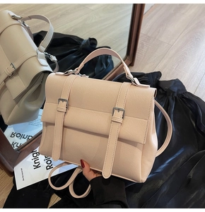 Dettaglio di zaino rosa chiaro in finta pelle con fibbie vintage e grana fine