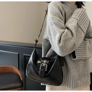 Detail der schwarzen Vintage-Schultertasche mit Lederstruktur und großer Silberschnalle