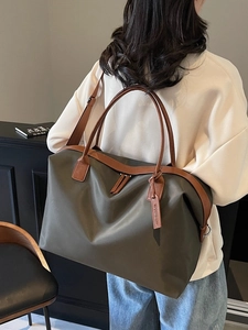 Large olive green nylon tote bag with brown leather handles for travel and daily use