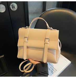Dettaglio dello zaino beige in ecopelle con fibbie argentate e manico superiore