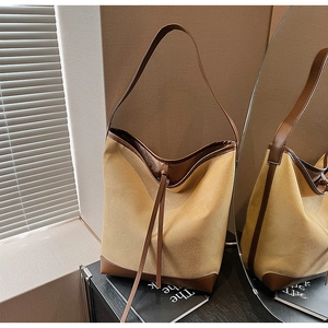 Detail of the high-quality stitching on brown suede and leather bucket shoulder bag