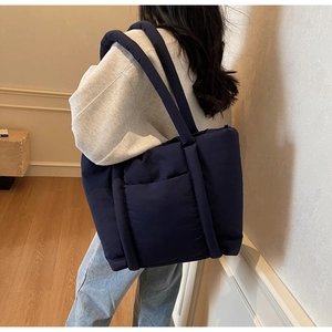 Vista dettagliata della borsa tote trapuntata blu navy con grande capacità e manici
