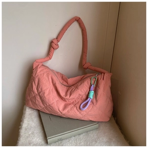 Pink quilted nylon tote bag detail with knotted shoulder strap and colorful rope charm