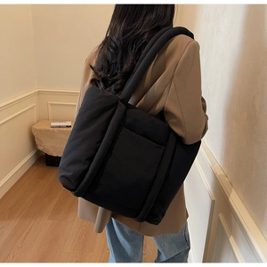 Dettaglio della borsa shopper nera trapuntata con tracolla imbottita e tasca