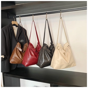 Detail view of large oil wax leather tote bags with metal buckle straps in four colors
