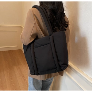 Dettaglio della borsa shopper trapuntata nera con spallacci spessi e grande capienza