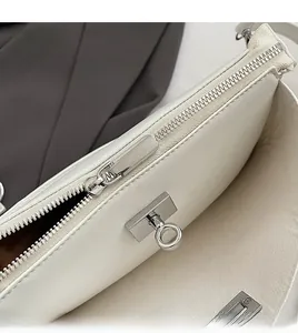 Detail of white leather shoulder bag with smooth silver zipper and round twist lock mechanism