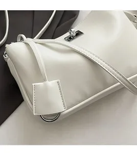 Detail of white leather shoulder bag with silver twist lock and square hangtag