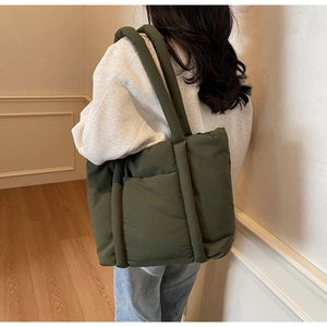 Dettaglio della borsa shopper imbottita verde oliva indossata a spalla con stile