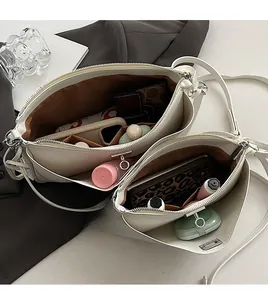 Macro detail of spacious interior with brown lining and items in a cream shoulder bag